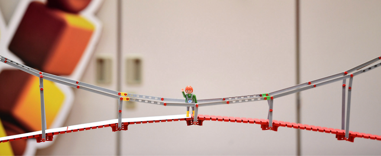 Playmobilfigur steht auf Miniatur-Brücke